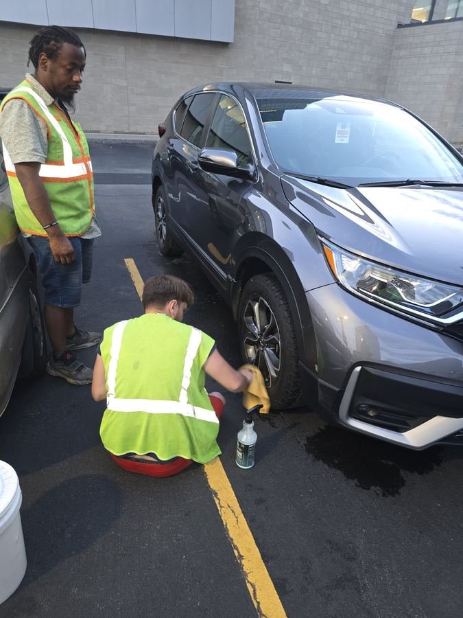 Slims crew detailing a vehicle on site — ceramic coating and paint protection work